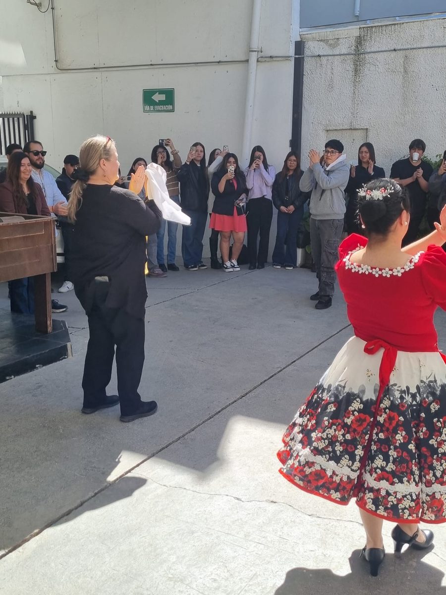 La profesora Isabel Wichmann Ginouves baila cueca durante la jornada, rodeada por estudiantes