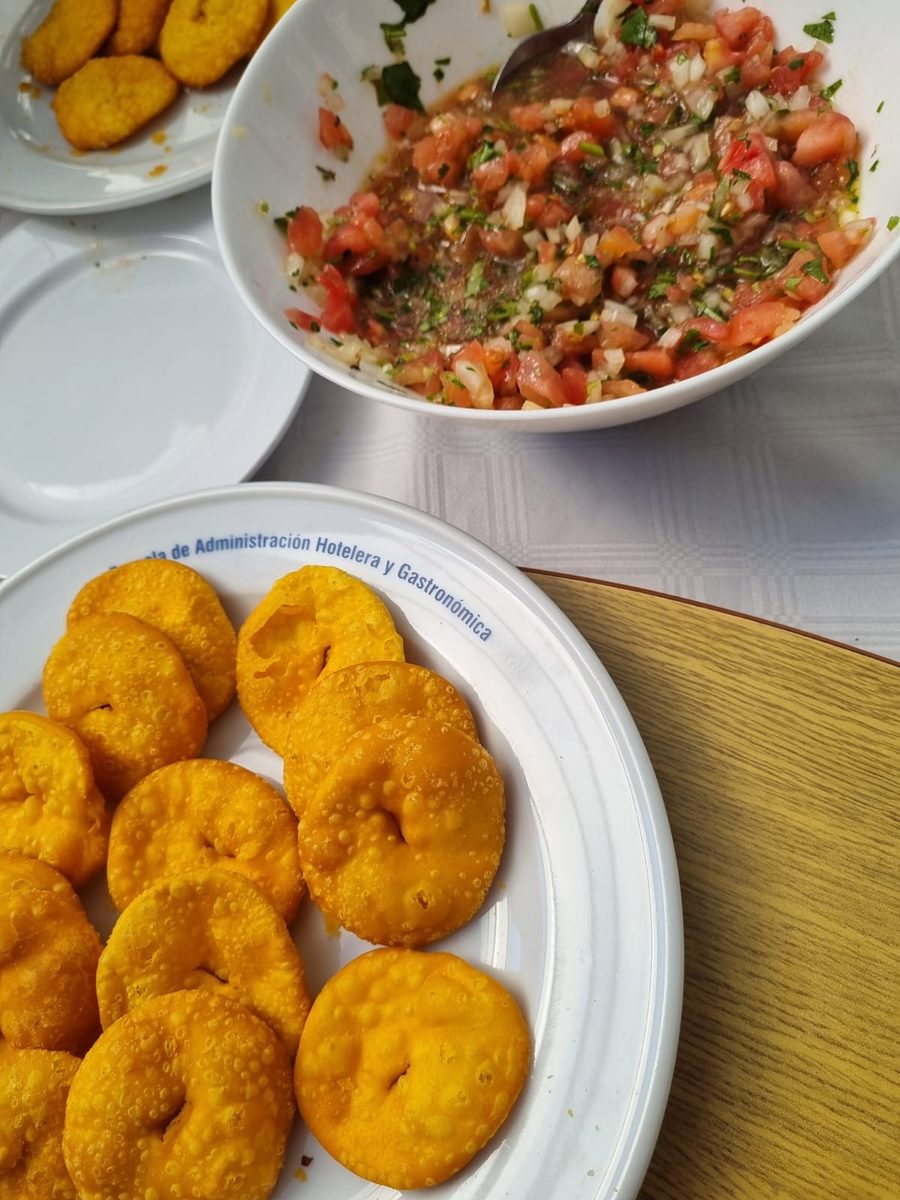 Sopaipillas recién fritas y un bowl de pebre servidos durante la jornada de Fiestas Patrias