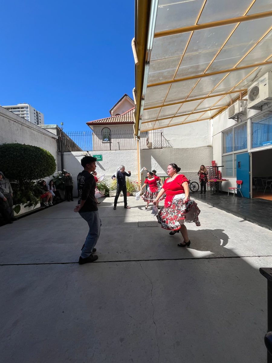 Asistentes bailando cueca en el patio de la sede de 5 Oriente