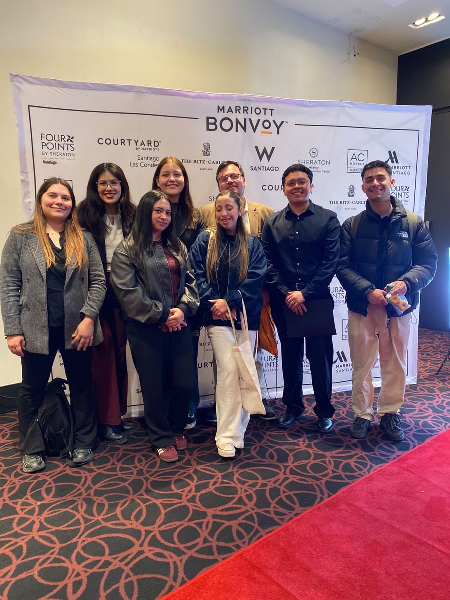 Estudiantes de la Escuela AHG UV frente al panel de marcas Marriott Bonvoy